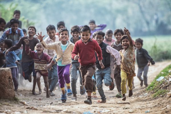 MATHURA, INDIA - Feburary 23,2018: Group of boisterous Indian children running for photograph in Agra, Uttar Pradesh, India.